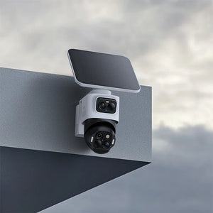 Security camera system with solar panel on a metallic surface against a cloudy sky.