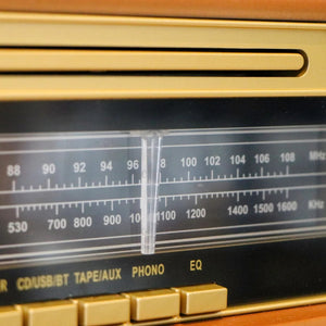 Vintage-style Lenco Classic Phono retro turntable with wooden cabinet, showing AM/FM radio tuner dial with frequency bands, brass accents, and cream-colored controls