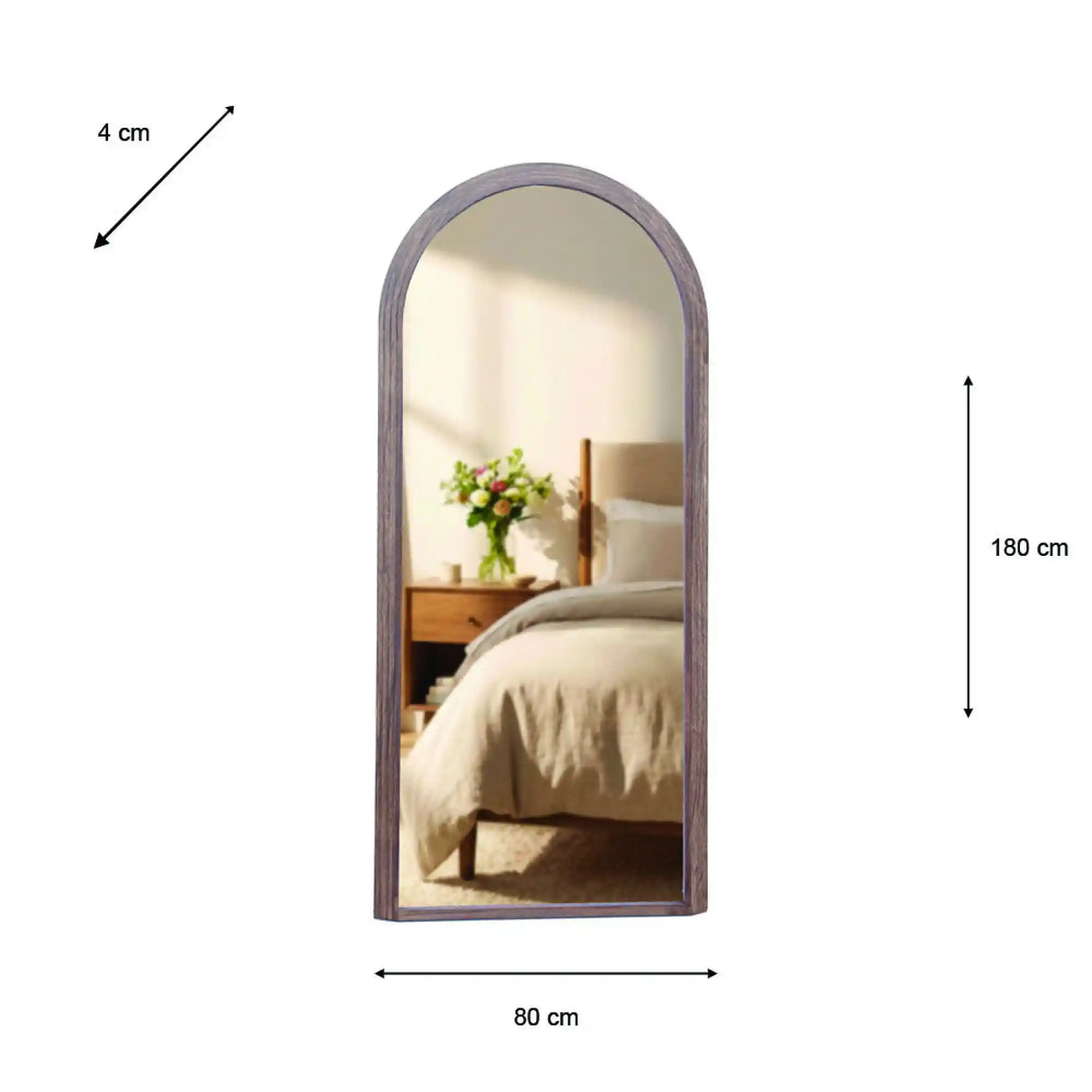 Tara Lane Stepped Arched Leaner Mirror 80cm x 180cm in natural wood frame leaning against bedroom wall, reflecting bed with white bedding and wooden nightstand with green flowers