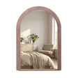 Tara Lane stepped arched wall mirror with natural wood frame reflecting a minimalist bedroom interior with bed, dresser and potted plant