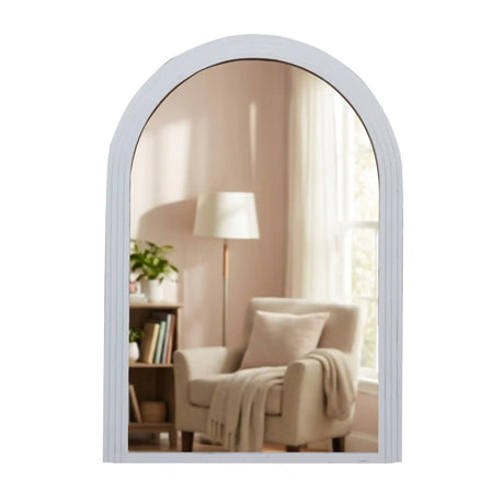 Tara Lane Stepped Arched Wall Mirror 70cm x 100cm in Oyster finish reflecting a modern living room with beige armchair, floor lamp and bookshelf