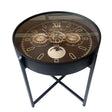 Black round side table with steampunk gear clock face design featuring Roman numerals, moon phase indicator, and gold mechanical details on brown dial, mounted on X-frame metal legs