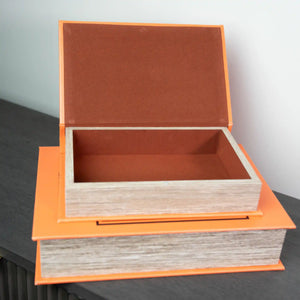 Two stacked decorative wooden book boxes with bright orange trim and natural wood sides, featuring terracotta-colored felt interiors, with the top box open to display storage space