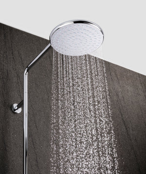 Chrome shower head with water stream on a gray background
