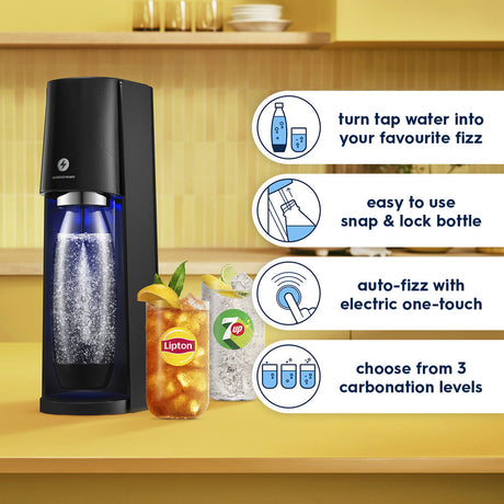 SodaStream E-Terra black sparkling water maker with blue bottle on yellow kitchen counter, displaying carbonated water and fizzy drinks with product features including snap-lock bottle, one-touch fizz button, and three carbonation level options