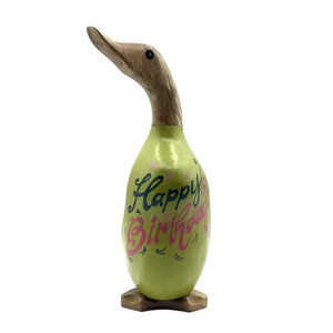 Wooden duck figurine with lime green body featuring "Happy Birthday" text in blue and pink lettering, natural wood carved head and neck, standing on wooden base