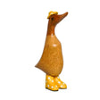 Wooden decorative duck figurine with brown body, long neck and head, wearing a yellow hat with bow detail and yellow wellington boots with white polka dots, 22cm tall