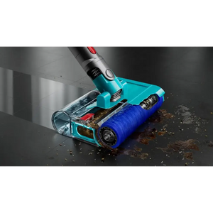 Dyson Cyclone V10 Submarine wet and dry cordless vacuum cleaner with turquoise and blue motorized cleaning head actively removing dirt and debris from dark floor, showing transparent dust chamber and silver metal handle with red power button