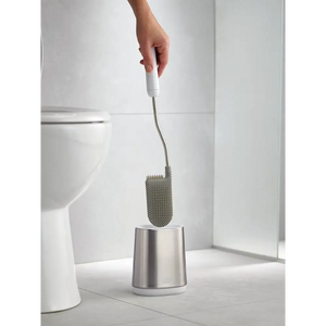 Joseph Joseph Flex Lite Steel Toilet Brush with white handle and stainless steel holder displayed in modern bathroom next to white toilet