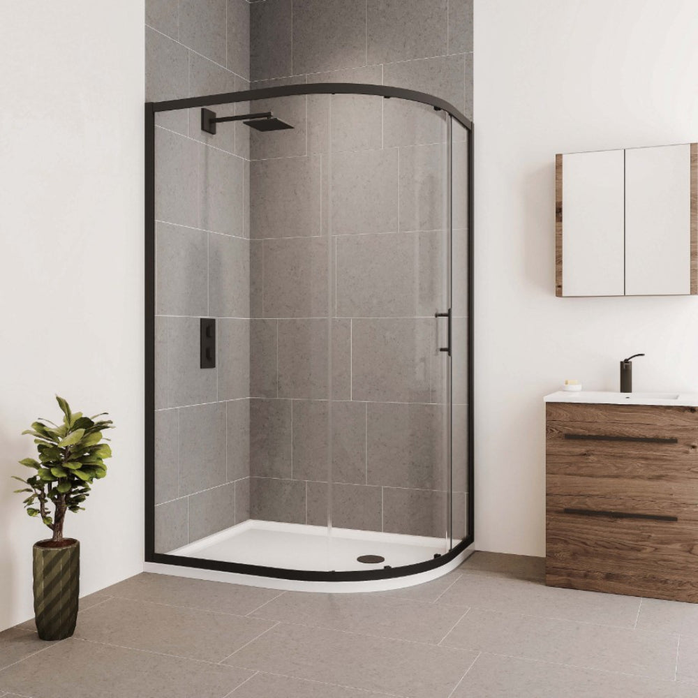 Modern bathroom with Flair Verve Pro black framed quadrant shower enclosure featuring curved glass door, grey tile walls, white base tray, wooden vanity unit with white basin, chrome tap, mirror cabinet, potted plant and neutral floor tiling