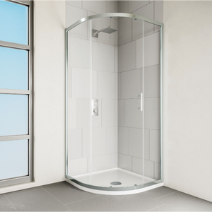 Modern chrome framed quadrant shower enclosure with curved glass doors, white curved tray base and grey tile surround in bright bathroom with window