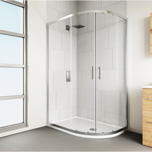 Modern chrome framed quadrant shower enclosure with clear glass panels and white curved base tray in contemporary bathroom with white subway tiles and wooden vanity