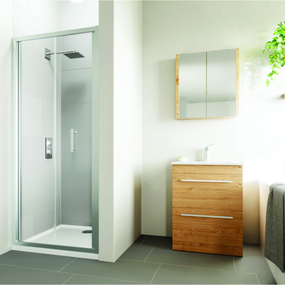 Flair VERVE PRO bifold shower door in chrome finish with clear glass panels installed in modern bathroom with grey tile flooring, wooden vanity cabinet, and mirrored medicine cabinet