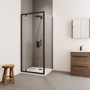 Modern bathroom interior featuring a black framed Flair Verve Pro pivot shower door with clear glass panels, gray tile walls and white base, alongside a wooden vanity unit with white sink, mirrored cabinet, and wooden stool on gray tile flooring