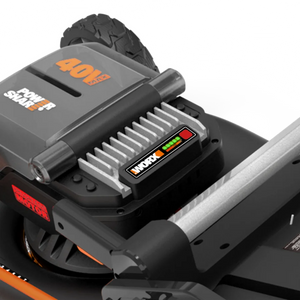 Worx 40V Brushless Self Propelled Battery Lawn Mower WG749E with 46cm cutting deck, featuring gray and black body with orange accents, battery pack with LED charge indicator, and black pneumatic tire visible from above angle