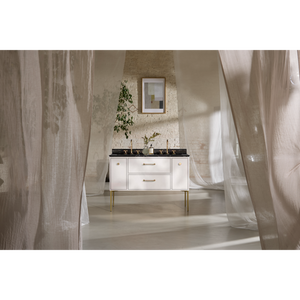 Modern white vanity unit with black countertop and brass handles in minimalist bathroom with exposed brick wall, framed mirror, potted plant, and sheer curtains