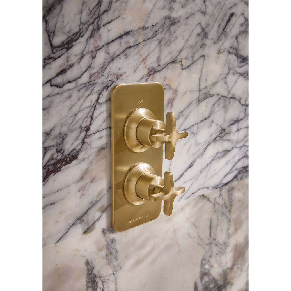 Roper Rhodes Walcot concealed shower valve in brushed brass with dual cross handles mounted on white marble tile wall