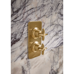 Roper Rhodes Walcot concealed shower valve in brushed brass with dual cross handles mounted on white marble tile wall