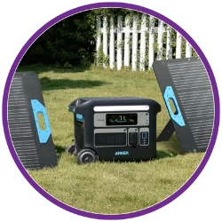 Portable power station on grass with a white fence in the background