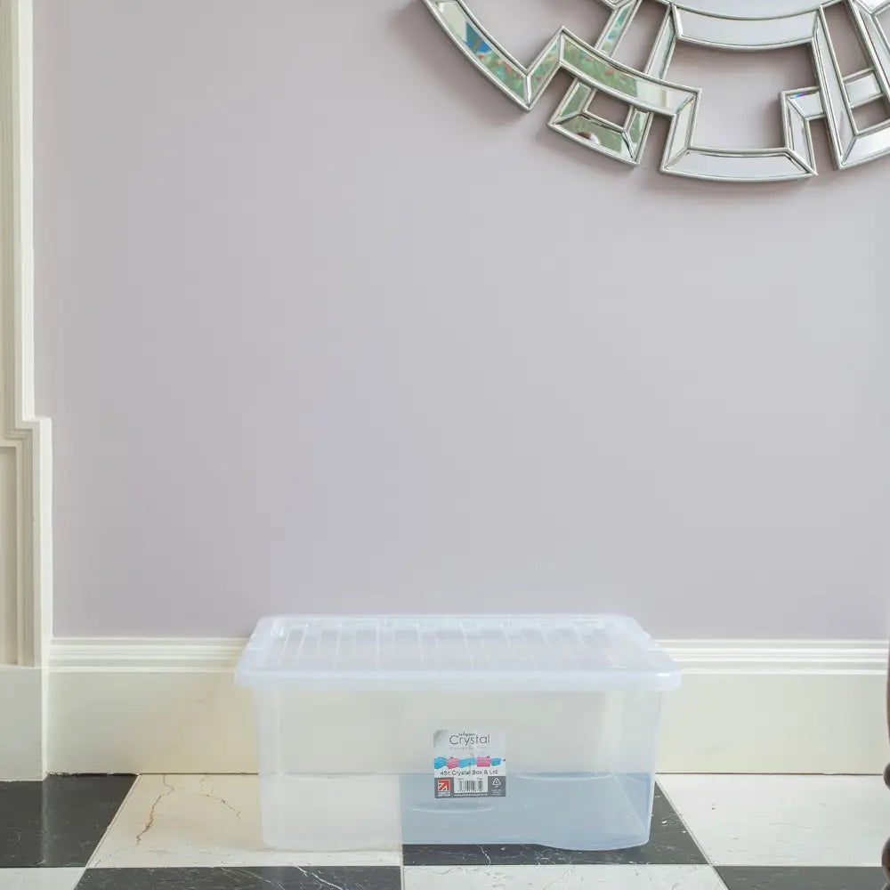 Clear plastic Wham storage box with lid 45 litre capacity positioned on black and white checkered floor against white and cream wall with decorative silver-framed mirrors above
