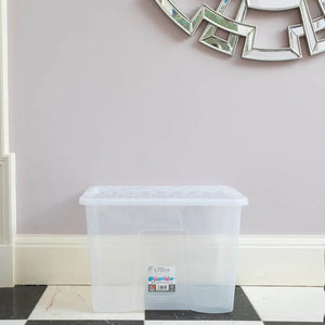 Clear plastic storage box with lid by Wham Crystal 80 litre capacity displayed on black and white marble floor against pale pink wall with white baseboards and decorative silver mirrors above