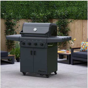 Black Sahara X450-S 4 burner gas BBQ grill with closed cabinet storage on wheels, positioned on a patio with wooden fence, potted plants and outdoor furniture in the background