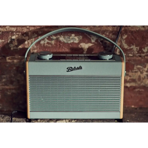 Roberts Rambler Max Smart DAB+ FM radio in duck egg blue with tan leather trim and carrying handle, displayed against a patterned brick background