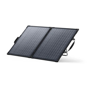 Anker SOLIX PS100 bifacial portable solar panel with two black-framed panels connected by hinges, featuring grey solar cells in a grid pattern, equipped with carrying handles, shown at an angled position against a white background