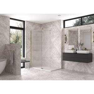 Modern luxury bathroom with Flair AYO 8mm wetroom panel in brushed brass finish, marble-effect grey wall tiles, dual rectangular mirrors with brass fixtures, dark grey vanity with white vessel sinks, freestanding white bathtub, black framed windows and natural lighting