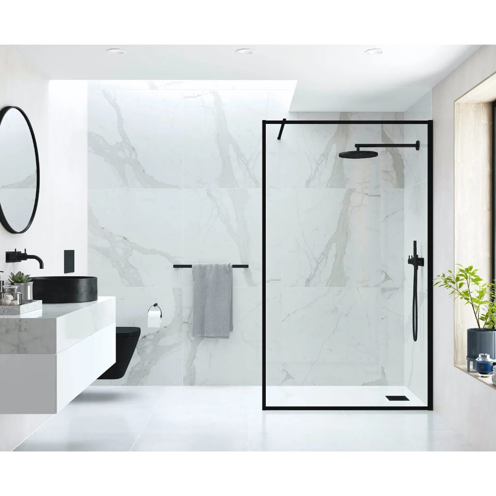 Modern bathroom featuring Flair AYO 8mm wetroom panel with matte black frame and clear glass, marble-effect wall tiles, black round sink, circular mirror, towel rail and rainfall showerhead in contemporary minimalist design