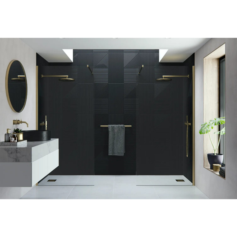 Modern luxury bathroom featuring Flair AYO 8mm wetroom panels in matte black with brushed brass hardware, black textured tile walls, white floor tiles, floating vanity with black round sink, oval brass mirror, and potted plant in niche