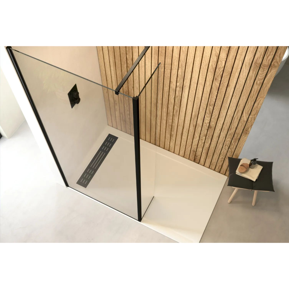 Modern bathroom wetroom setup featuring Flair AYO 8mm glass panels with matte black frame, cream tile flooring, wooden wall paneling, linear floor drain, and minimalist black side table with accessories