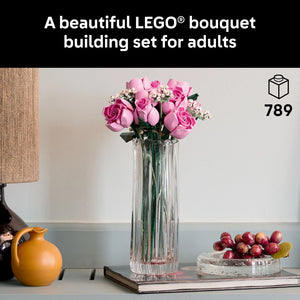 LEGO Bouquet building set featuring pink roses and white flowers in a clear glass vase, displayed on a styled surface with a yellow pitcher, grapes, and book, 789 pieces, adult building set