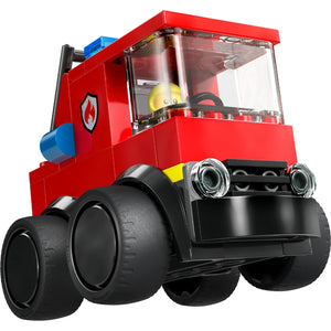LEGO bright red fire truck toy with large black wheels, yellow helmet visible in cockpit window, blue siren light on roof, and silver chrome headlights, featuring classic LEGO brick construction style