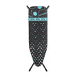 Minky Hotspot ironing board with black cover featuring turquoise and grey polka dot pattern, tripod legs, and branded tape band around the top