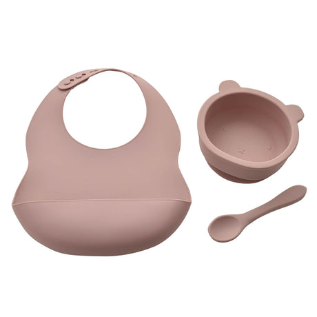 Pink silicone bib, bowl, and spoon set on a white background