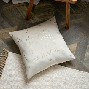 Decorative pillow with 'Love you to the moon and back' text on a wooden floor.