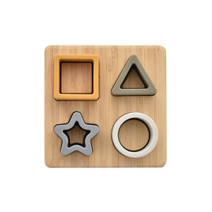 Wooden shape sorting toy with square, triangle, star, and circle cutouts on a white background