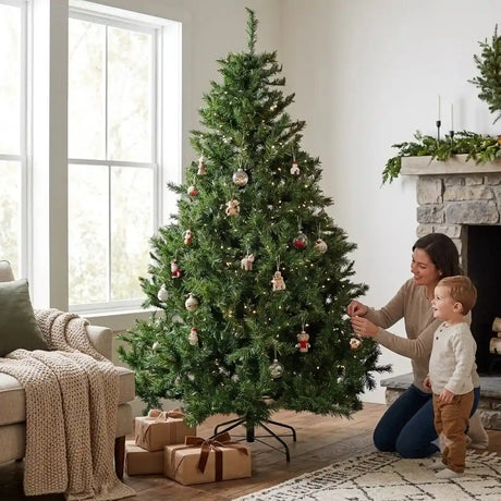 Woman and toddler decorating a full, lush green 7ft Colorado Fir artificial Christmas tree with baubles and ornaments in a bright living room with fireplace, couch, window and wrapped presents underneath
