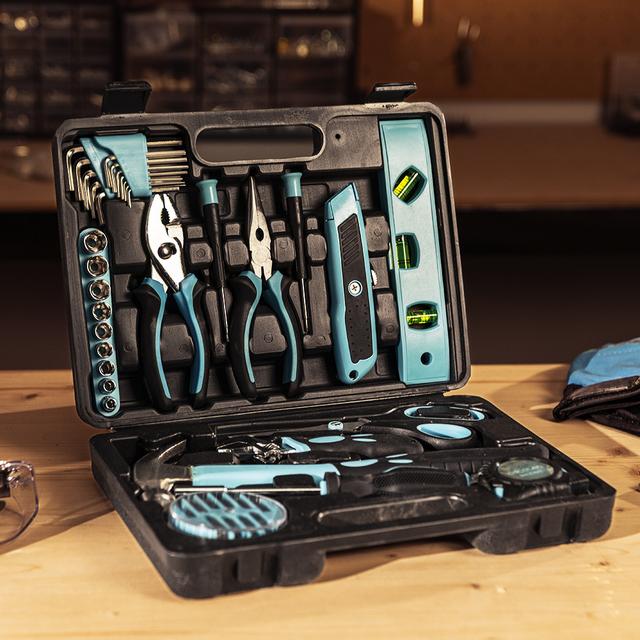 Open tool kit with various tools on a wooden surface