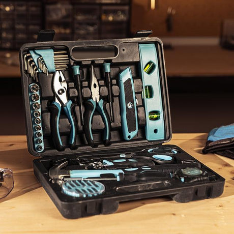 Open tool kit with various tools on a wooden surface