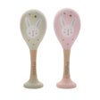 Two maraca toys with rabbit designs on beige and pink backgrounds