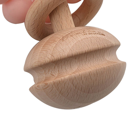 Wooden teething rattle toy with natural light wood finish featuring a rounded bulbous shape and curved handles, displayed with pink silicone attachment at top