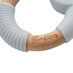 Bambino Teddy Teether with natural wood handle and white textured silicone ring, held in hand against white background