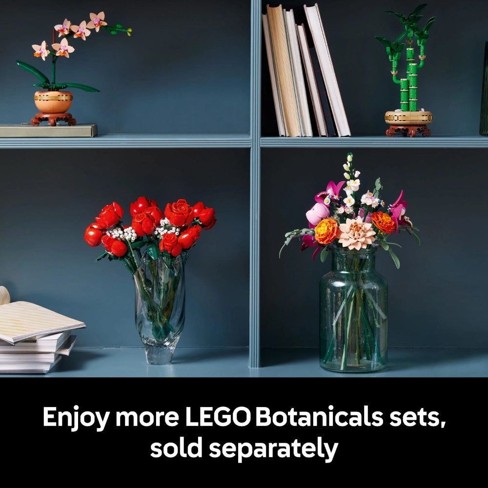 LEGO Botanicals Pretty Pink Flower Bouquet set 10342 displayed in clear glass vase with pink, coral and white flowers alongside other LEGO flower arrangements on blue shelving unit