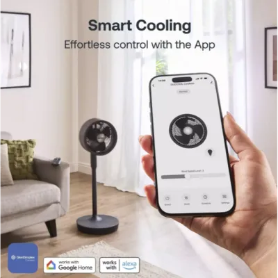 Hand holding smartphone displaying smart cooling app interface for Dimplex Duocool 2-in-1 graphite pedestal fan with Google Home and Alexa compatibility icons shown in modern living room setting