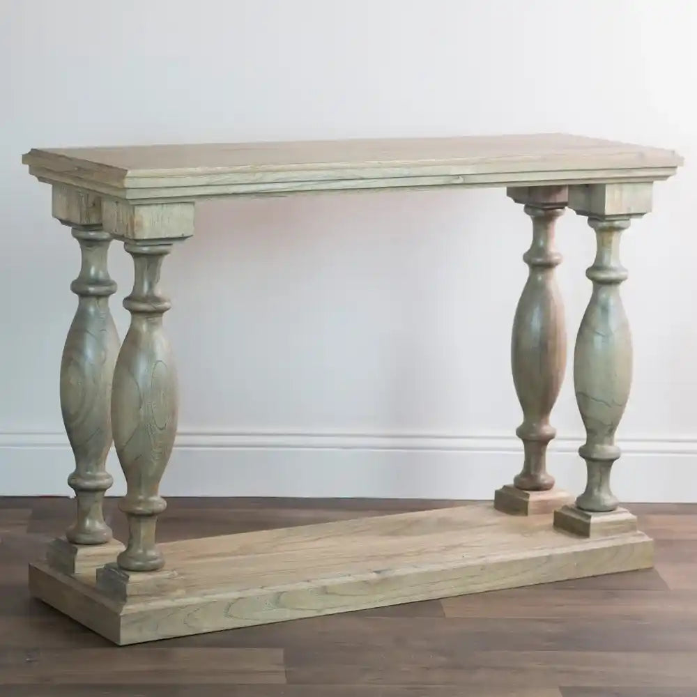 Tara Lane Pillars Console Table 120cm in whitewashed wood with turned baluster legs on wooden base displayed against white wall on dark hardwood floor