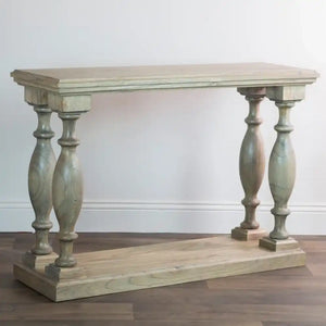 Tara Lane Pillars Console Table 120cm in whitewashed wood with turned baluster legs on wooden base displayed against white wall on dark hardwood floor