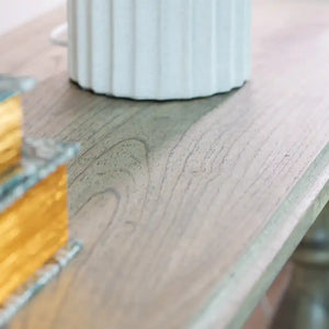 Close-up detail of Tara Lane Pillars Console Table showing light wood grain texture with white fluted pillar base and yellow measuring tape