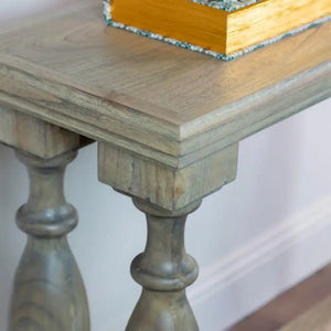 Tara Lane Pillars Console Table 120cm in natural wood finish with turned pedestal legs, featuring a light oak top surface and decorative items displayed on top